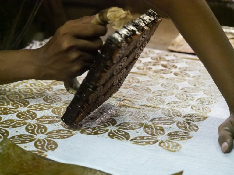 person holding brown metal manual printing stamp